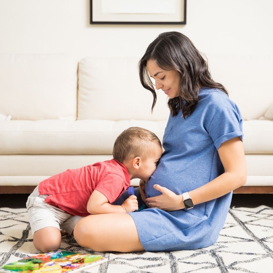 Pregnant mom and her toddler on floor